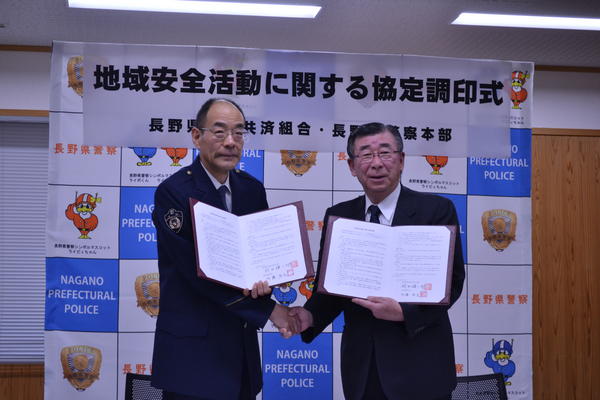 協定調印式で握手を交わす内藤県警本部長（左）と羽田組合長（右）